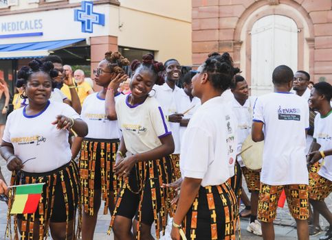 Colorful dancers and performers celebrate during an outdoor cultural parade.