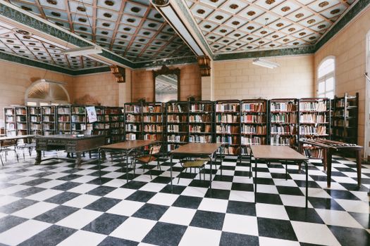 Spacious library interior with books, shelves, and tables. Ideal for study.