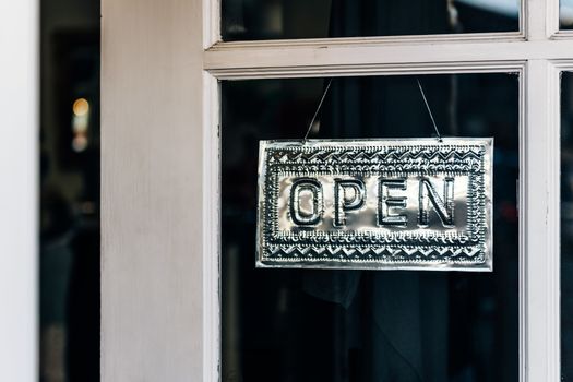 Metal open sign hanging on a shop door in Paso Robles, California.