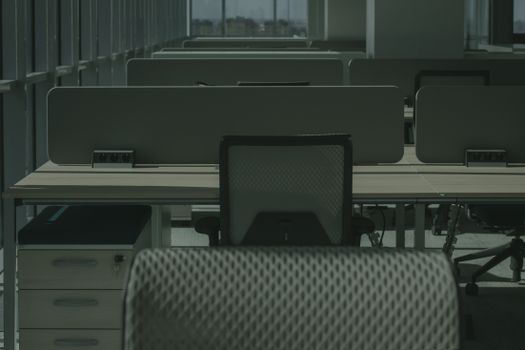 A sleek modern office with multiple desks and chairs, showcasing an empty and orderly workspace.